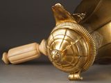 a gold vase with a wooden handle on a table