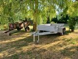 une remorque blanche garée sous un arbre dans un champ