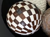 three decorative balls in a black bowl on a table