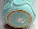 a blue vase sitting on a table with a tag on it