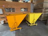 deux bennes jaunes dans un entrepôt, avec des palettes de bois