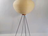 a white lamp with a wooden base on a tripod stand