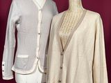two women ' s sweaters on a mannequin stand against a red wall
