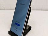 a close up of a cell phone on a stand on a white surface