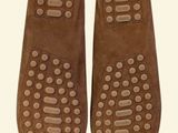 pair of brown slippers with holes on them sitting on a white surface