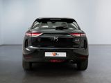 the rear end of a black car in a white room