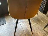 a yellow chair sitting in front of a glass table