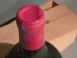 a bottle of wine sitting on a table next to a wooden box