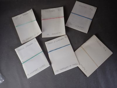 several pieces of paper with writing on them sitting on a table