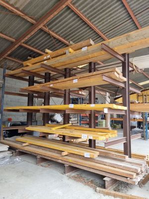 many wooden shelves in a warehouse with a metal roof
