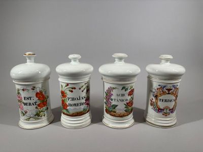 three white ceramic jars with floral designs on them sitting on a table