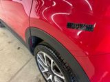 a close up of a red car parked in a parking lot
