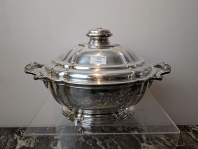 a silver plate with a glass lid on a marble table