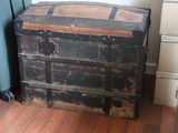 an old wooden chest sitting on the floor next to a dresser