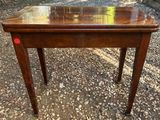 an old wooden table with a red button on the top