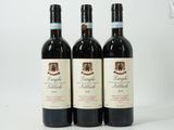 three bottles of red wine sitting on top of a white table