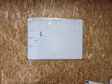 a white board on the wall next to a pile of papers