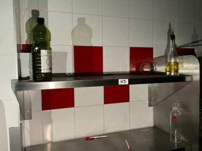 une étagère en métal sur laquelle sont posées des bouteilles et une bouteille de vin