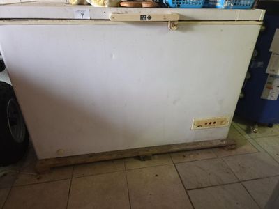 un réfrigérateur blanc posé dans une cuisine à côté d'un réfrigérateur bleu