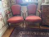 two red chairs sitting next to each other in a room