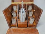 a wooden box with a set of glasses and a bottle in it