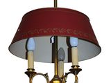a chandelier with a red shade hanging from it ' s ceiling