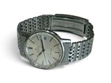 a watch that is sitting on a bracelet on a white surface