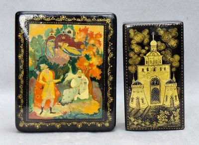 deux boîtes noires et dorées ornées de peintures, posées l'une à côté de l'autre