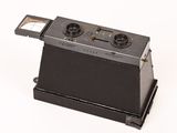 an old photo of a black camera on a white surface