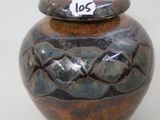 a brown and black vase with a tag on it