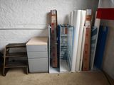 une pile de livres sur une étagère à côté d'un classeur