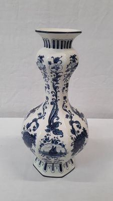 un vase bleu et blanc posé sur une table blanche