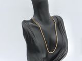 a black mannequin head with a gold chain on it