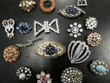 many different types of brooches on a black surface