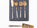 four silverware pieces in a box with a spoon and a spatula