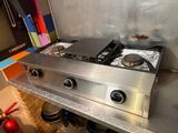 une plaque de cuisson en acier inoxydable dans une cuisine équipée d'un extincteur
