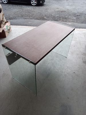 a glass table with a wooden top sitting on the sidewalk