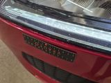 a close up of a car ' s headlight with a sticker on it