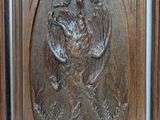 a wooden door with a carving of a bird on it