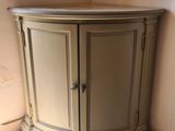 une armoire d'angle placée dans un coin de la pièce