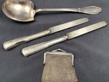 three silverware items including a purse, spoon, and knife