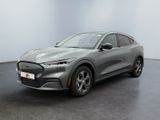 Une Ford Mustang Macht 2020 grise est garée dans une pièce blanche