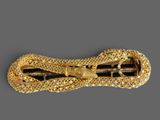 a close up of a gold colored hair clip with a snake on it