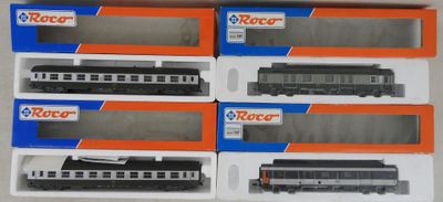 Six trains miniatures sont rangés dans une boîte posée sur une table