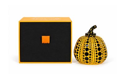 an orange and black ceramic pumpkin sitting next to a black box