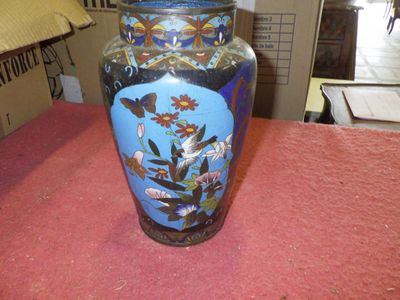 a blue vase sitting on a table with a pink table cloth