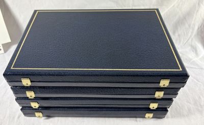 un ensemble de quatre coffrets en cuir noir ornés de finitions dorées