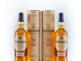 trois bouteilles de whisky sont posées les unes à côté des autres sur une surface blanche