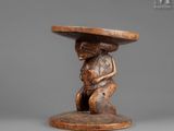 a small wooden table with a monkey holding a bowl on top of it