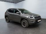 a grey jeep compass is parked in a large room